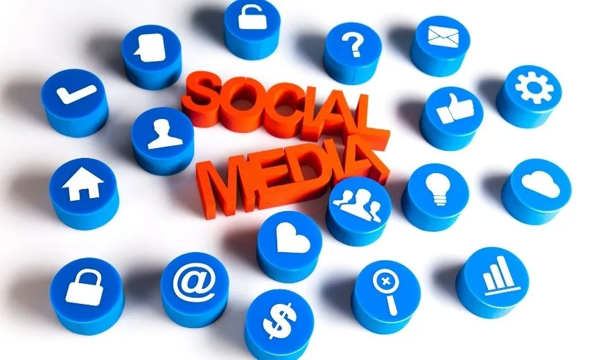 Iconos azules de redes sociales formando un círculo alrededor del texto ‘Social Media’, representando la importancia de las redes sociales en las páginas web.