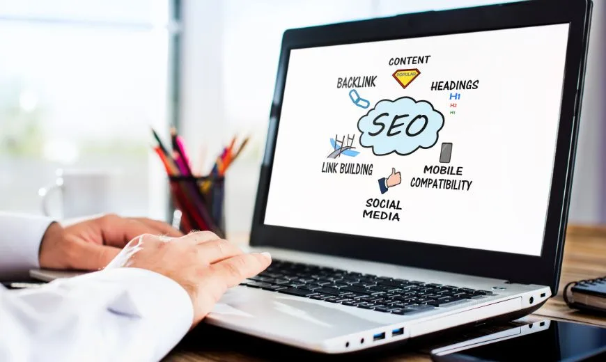 Persona utilizando una laptop con un diagrama de SEO en la pantalla, ilustrando estrategias SEO efectivas para pequeñas empresas.